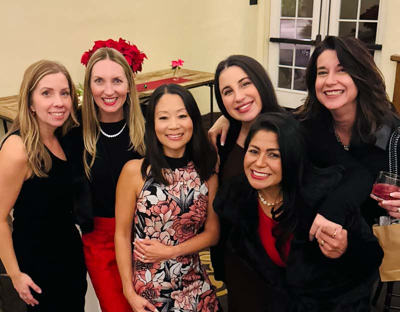 Five professional women at a formal networking event